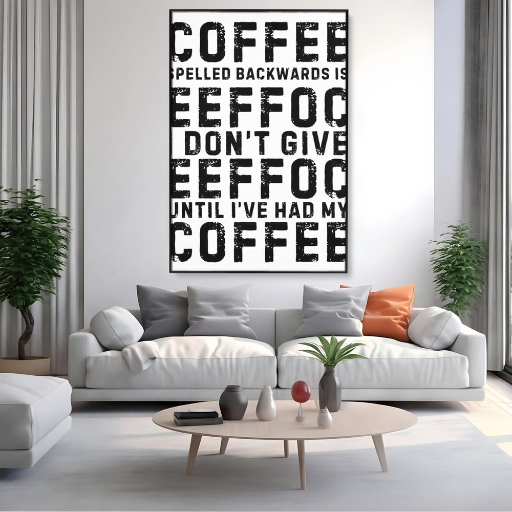Tablou canvas cu tablou canvas cu mesaj motivational despre cafea, in rama de aluminiu negru, pe perete intr-un living